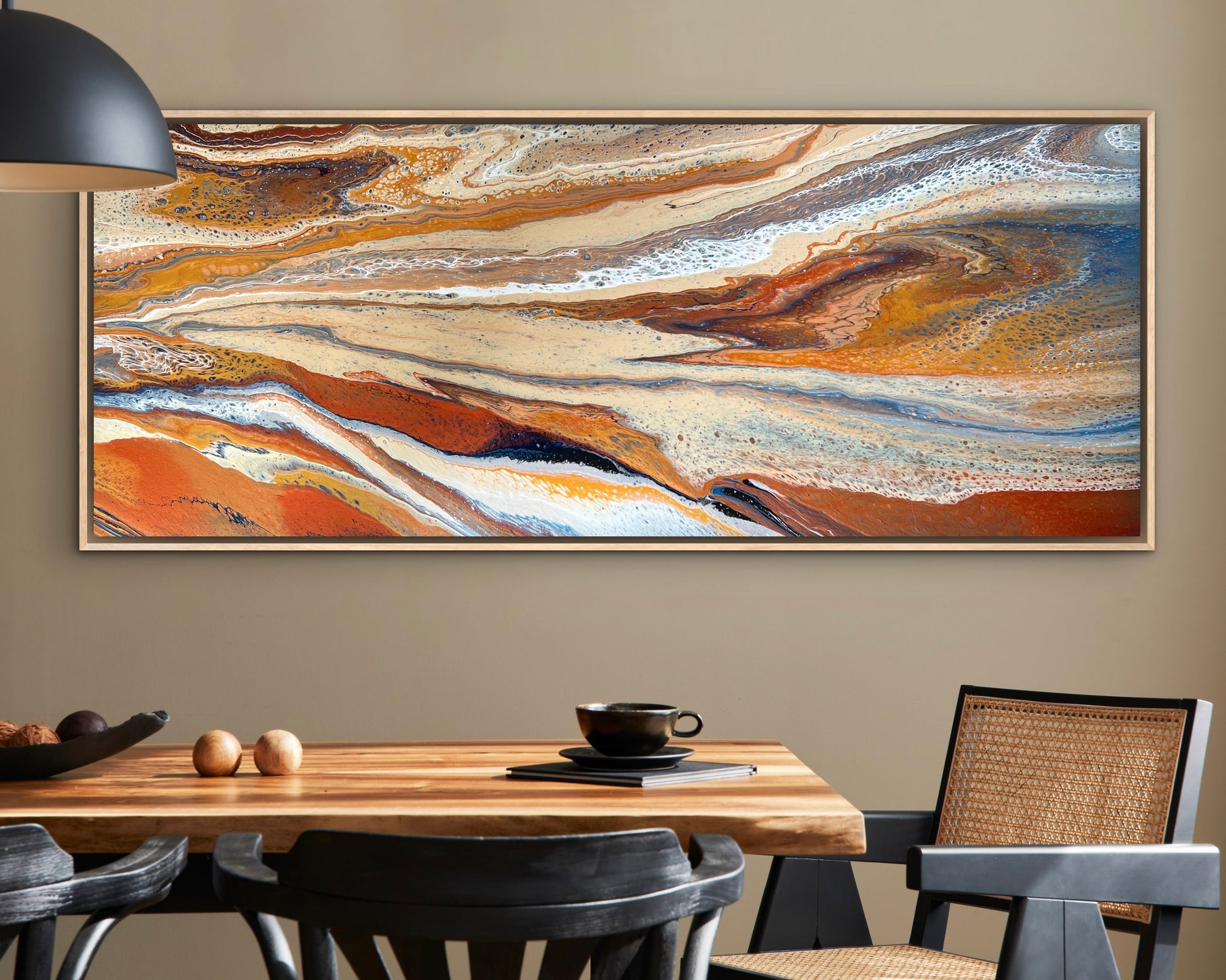 Desert Drift original horizontal wall art in rust, cream and blue, displayed in an oak frame above a timber dining table in a modern interior