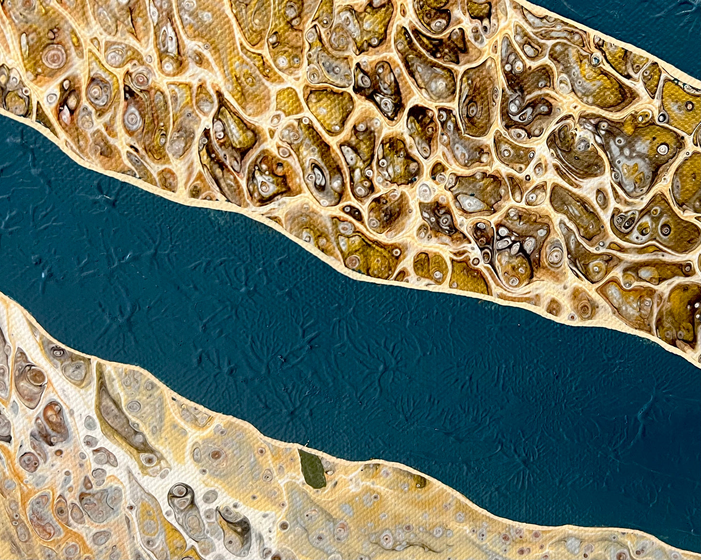 Detailed close-up of Rivers Divide showing the tactile deep blue textured surface, hand-painted cream outlines and intricate gold and bronze cellular patterns