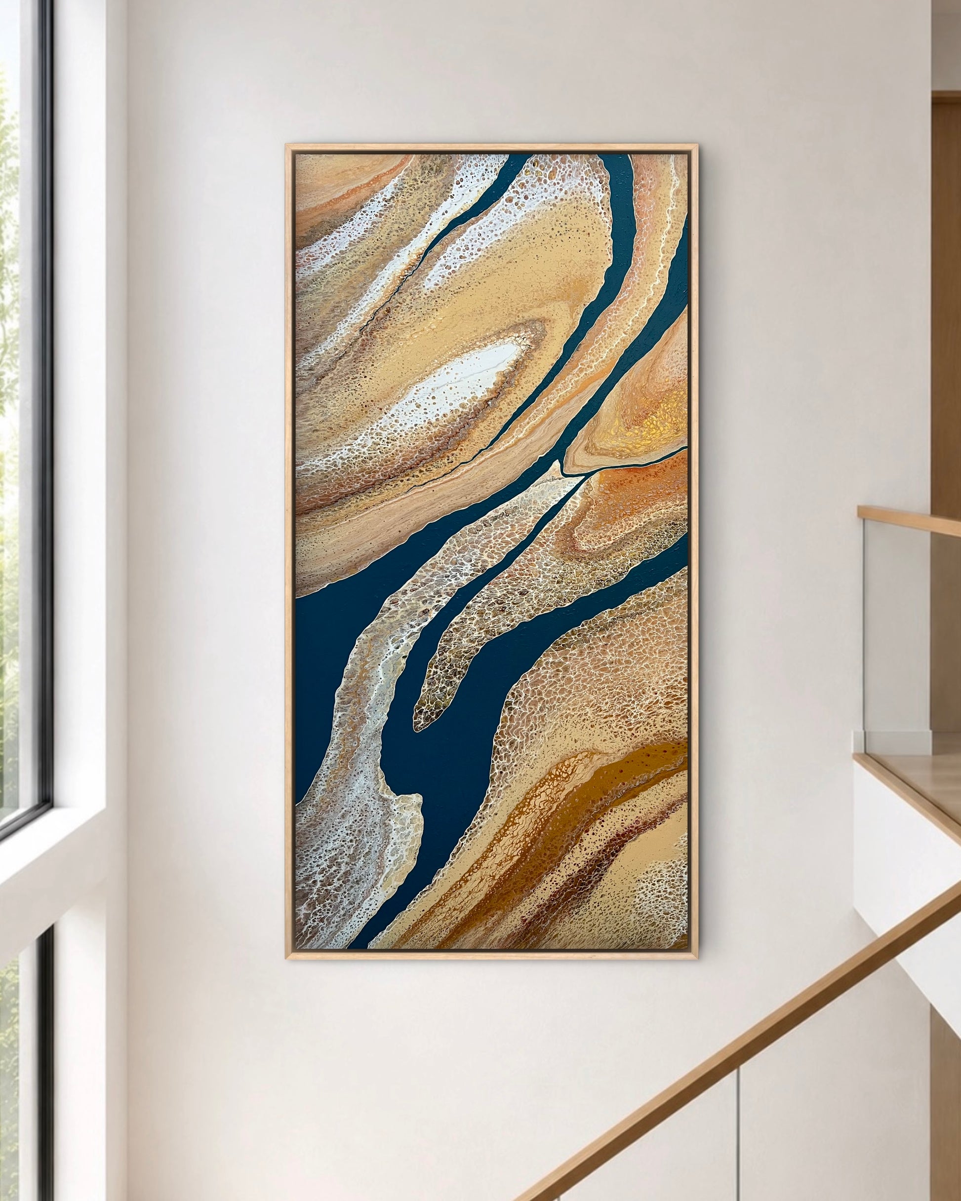 Rivers Divide extra-large original textured abstract painting displayed vertically beside a modern staircase, showing its deep navy, gold and cream detail